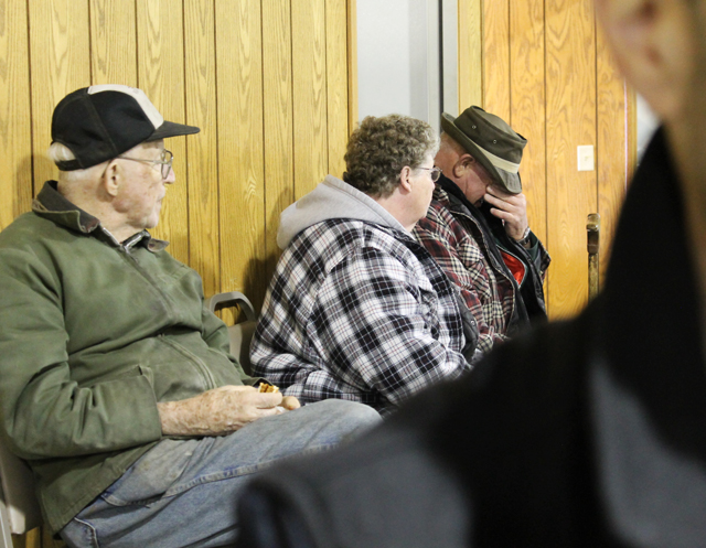 a man eats a sandwich at a country auction
