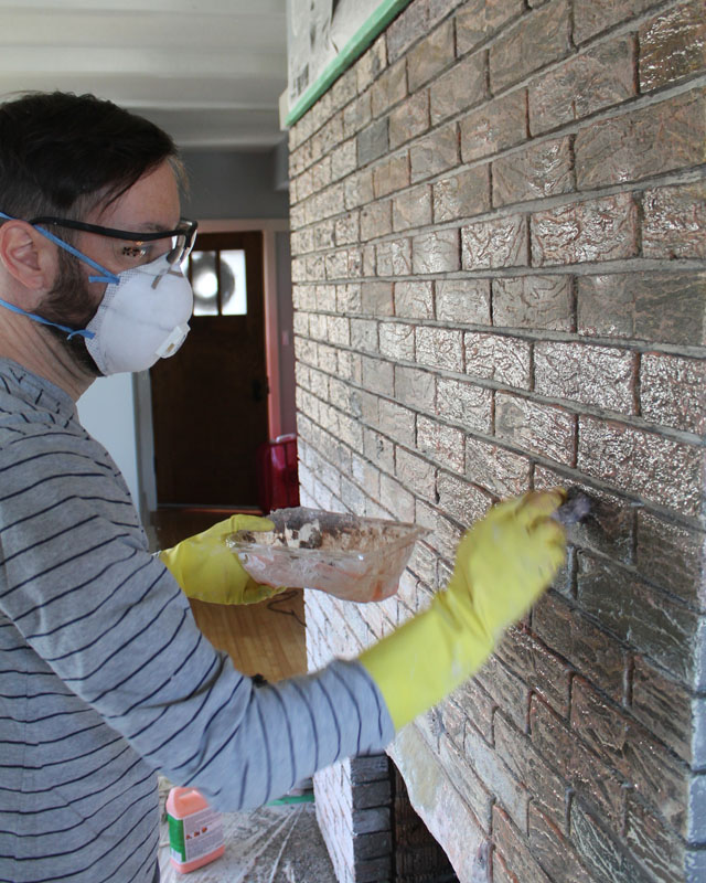 Applying Citri-strip the fireplace brick