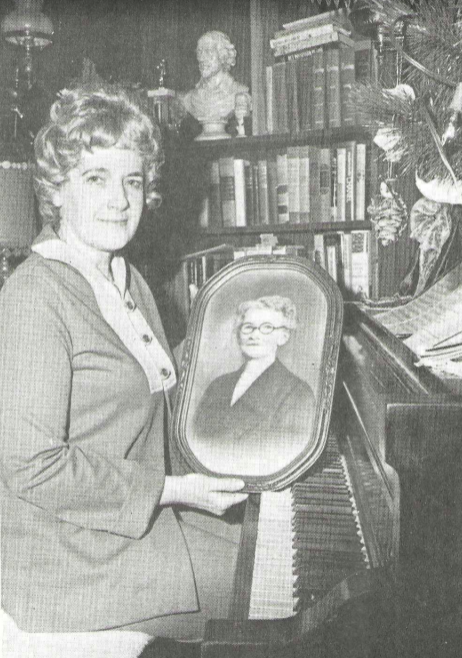 Hope Rogers poses at her piano with a portrait of her grandmother, Elizabeth Wright Heller, in a press photo taken on the publication of Grandpa Wright